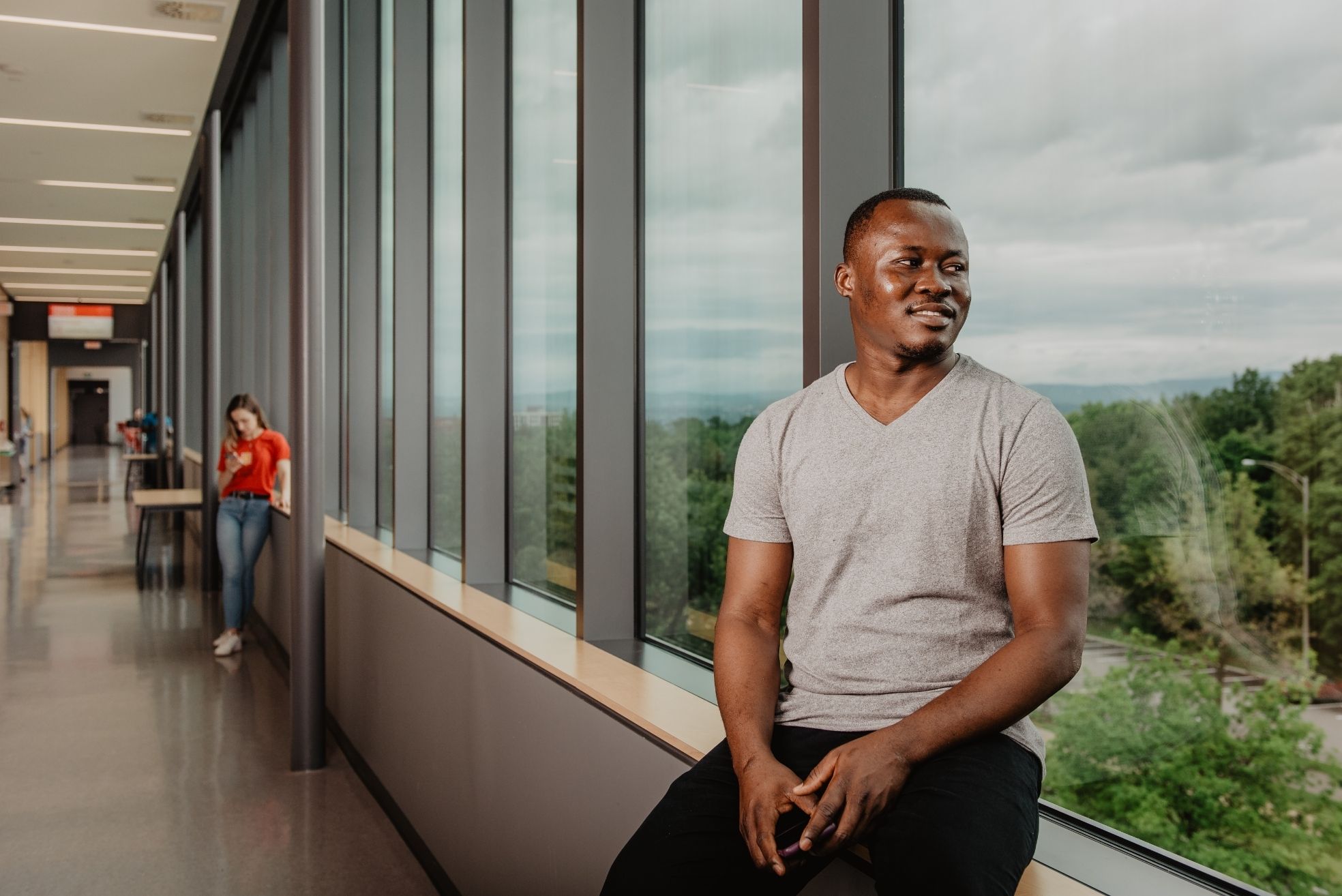 Étudiant assis sur le rebord d'une fenêtre